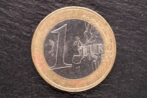 Several metal coins of the European Union on slate stones, close-up, top view.