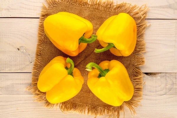Four Ripe Yellow Sweet Peppers Jute Napkin Wooden Table Close — ストック写真