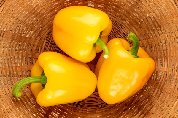 Three Ripe Yellow Sweet Peppers Straw Plate Close Top View — Stockfoto