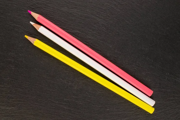 三支彩色铅笔在石板上 顶视图 — 图库照片