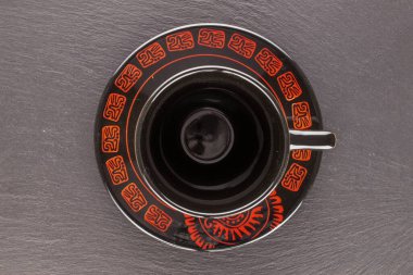 Bir sade seramik kahve fincanı, tabağı kayrak taşı üzerinde, yakın plan, üst manzara..