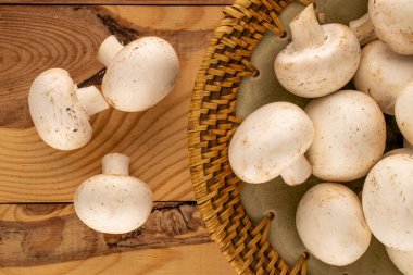 Ahşap masa üzerinde seramik kaplama ile çeşitli aromatik organik mantarlar, yakın çekim, üst görüş.