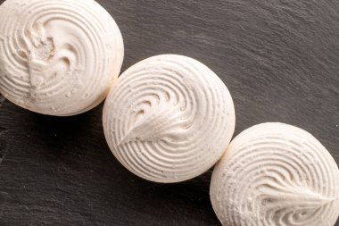 Kayrak taşı üzerinde üç tatlı beyaz marşmelov, makro, üst manzara..