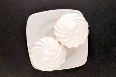 Beyaz seramik tabağı olan iki tatlı beyaz marşmelov kayrak taşı, makro, üst manzara..