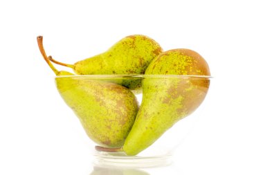 Cam bir kasede üç sulu yeşil armut, makro, beyaz arka planda izole edilmiş..