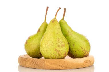 Tahta bir çanakta üç sulu organik armut, yakın plan, beyaz arka planda izole edilmiş..