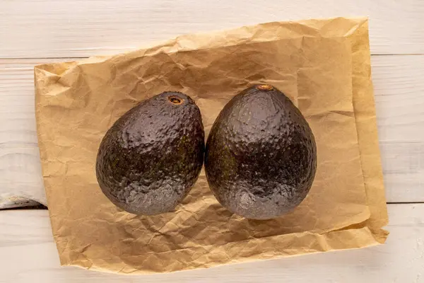 Due Avocado Maturi Con Sacchetto Carta Tavolo Legno Macro Vista — Foto Stock