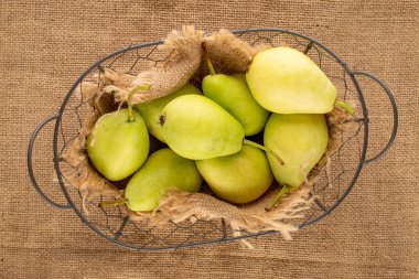 Jüt kumaş, makro, üst manzara sepetinde birkaç tatlı armut..