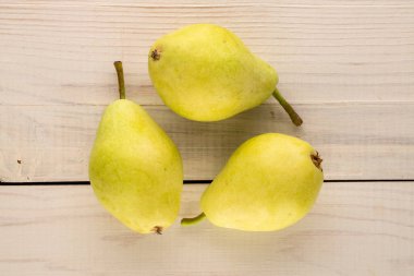 Tahta bir masada üç tatlı armut, makro, üst manzara..