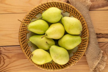 Tahta bir masada seramik bir tabakta birkaç tatlı armut, makro, üst manzara..