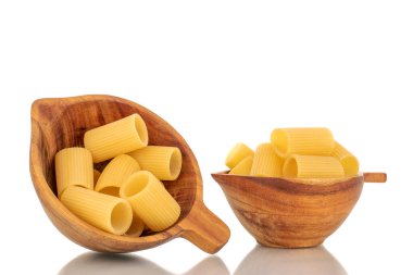 İki tahta fincanda birkaç çiğ sarı cannelloni, makro, beyaz arka planda izole edilmiş..