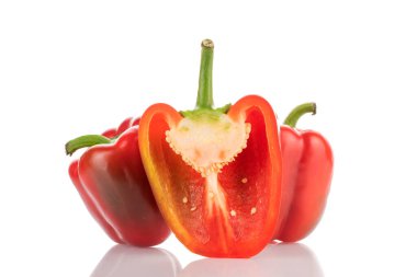 Yarısı ön planda, ikisi de arka planda kırmızı dolmalık biber, yakın plan, beyaz üzerine izole edilmiş..