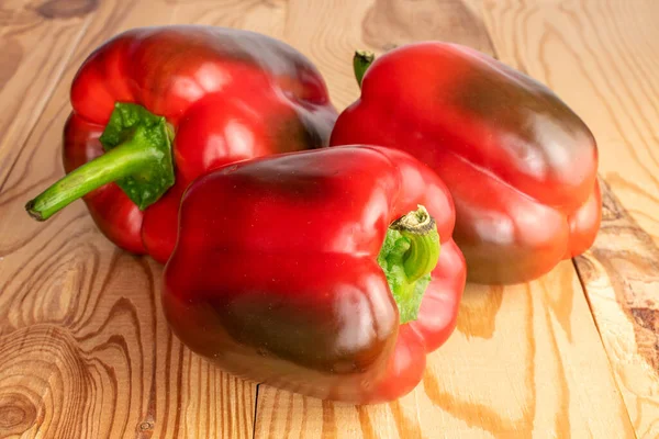 Drei Rote Bio Paprika Großaufnahme Auf Einem Holztisch — Stockfoto