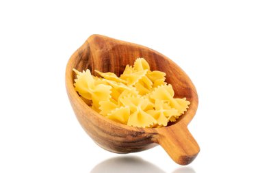 Tahta bir fincanda birkaç çiğ kelebek makarna, makro, beyaz arka planda izole edilmiş..