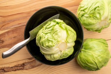  Siyah bir tabak ve bıçakla üç lezzetli doğal lahana, yakın plan, boyalı ahşap bir masa, üst görüş..