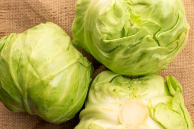 Jüt kumaş üzerinde üç taze lahana, makro, üst görünüm..