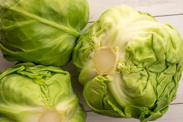 Två Färska Saftiga Ekologiska Kål Närbild Ett Målat Träbord Ovanifrån — Stockfoto