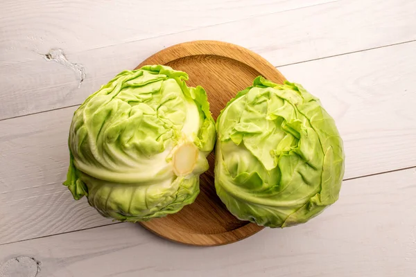 İki olgun, sulu lahana, bambu tepsiyle boyanmış ahşap bir masanın üstünde..