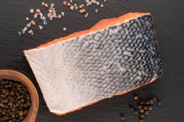 Bir parça taze somon fileto, biber ve tuz ile kayrak taşı, makro, üst manzara..