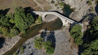 Aziz Aga 'nın eski taş köprüsü, Venetikos nehri, hava aracı manzarası, Grevena, Makedonya, Yunanistan