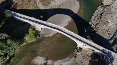 Aziz Aga 'nın eski taş köprüsü, Venetikos nehri, hava aracı manzarası, Grevena, Makedonya, Yunanistan