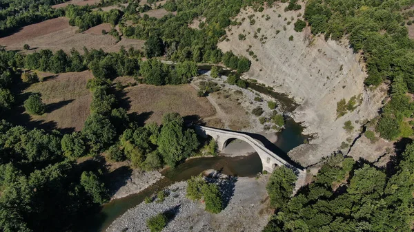 Aziz Aga 'nın eski taş köprüsü, Venetikos nehri, hava aracı manzarası, Grevena, Makedonya, Yunanistan