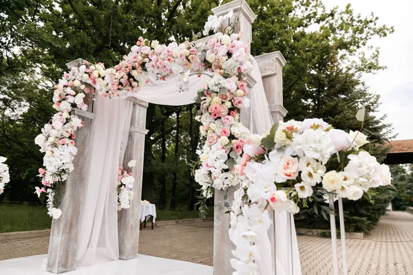 Cerimônia de casamento decorada com flores e tecidos em cores claras no arco — Fotografia de Stock