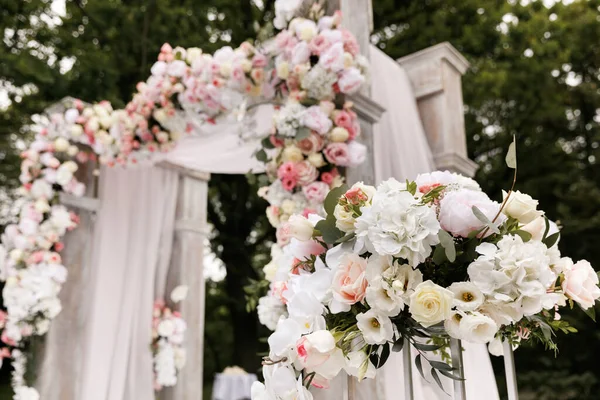 Cerimônia de casamento decorada com flores e tecidos em cores claras no arco — Fotografia de Stock