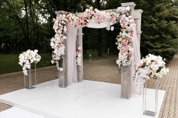Cerimônia de casamento decorada com flores e tecidos em cores claras no arco — Fotografia de Stock