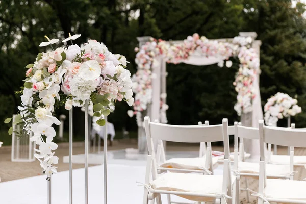 Τελετή γάμου διακοσμημένη με λουλούδια και υφάσματα σε ανοιχτόχρωμα χρώματα στην αψίδα — Φωτογραφία Αρχείου