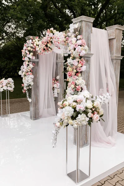Cerimônia de casamento decorada com flores e tecidos em cores claras no arco — Fotografia de Stock