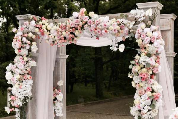 Cerimônia de casamento decorada com flores e tecidos em cores claras no arco Imagens Royalty-Free