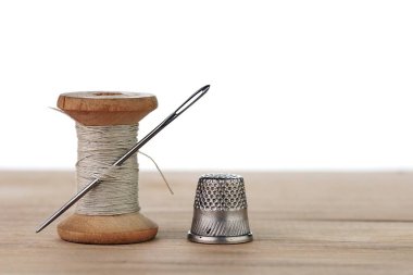 İğneli eski bir iplik makarası. Terzinin çalışma masası. Tekstil ya da kumaş yapımı..