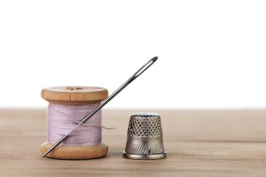 İğneli eski bir iplik makarası. Terzinin çalışma masası. Tekstil ya da kumaş yapımı..