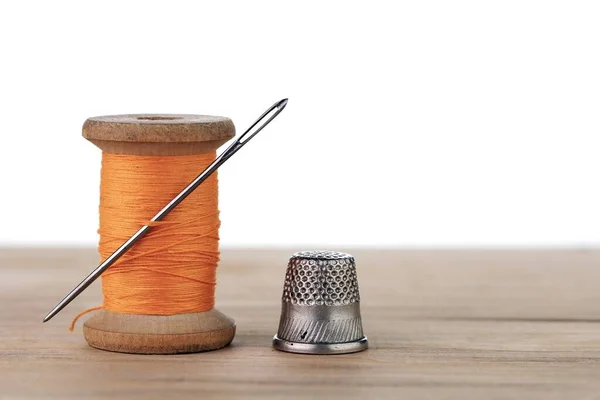 İğneli eski bir iplik makarası. Terzinin çalışma masası. Tekstil ya da kumaş yapımı..