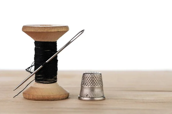 İğneli eski bir iplik makarası. Terzinin çalışma masası. Tekstil ya da kumaş yapımı..