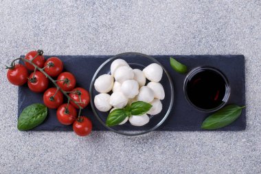 Mozzarella peyniri, fesleğen ve kirazlı gri taş masa fotokopi alanı. İtalyan Caprese salatası için malzemeler