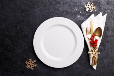 Siyah taş masa, kart ya da menü şablonu üzerinde altın çatal bıçak seti ile noel ya da yeni yıl sofrası düz yatıyordu