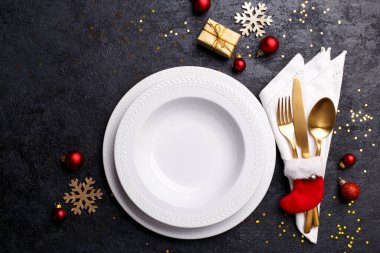 Siyah taş masa, kart ya da menü şablonu üzerinde altın çatal bıçak seti ile noel ya da yeni yıl sofrası düz yatıyordu