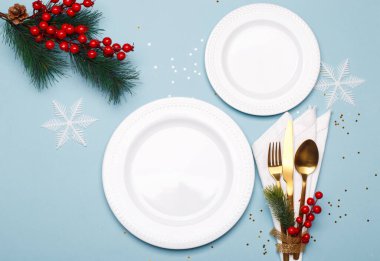 Christmas or new year table setting with golden cutlery on the blue background with copy space