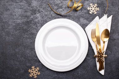 Siyah taş masa, kart ya da menü şablonu üzerinde altın çatal bıçak seti ile noel ya da yeni yıl sofrası düz yatıyordu