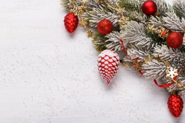 Christmas red and gold ornaments on the white background with snow copy space top view