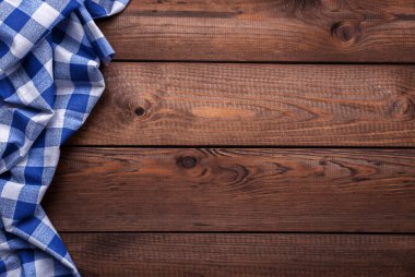 Old vintage planked wood board with blue checkered table cloth, background with space for text