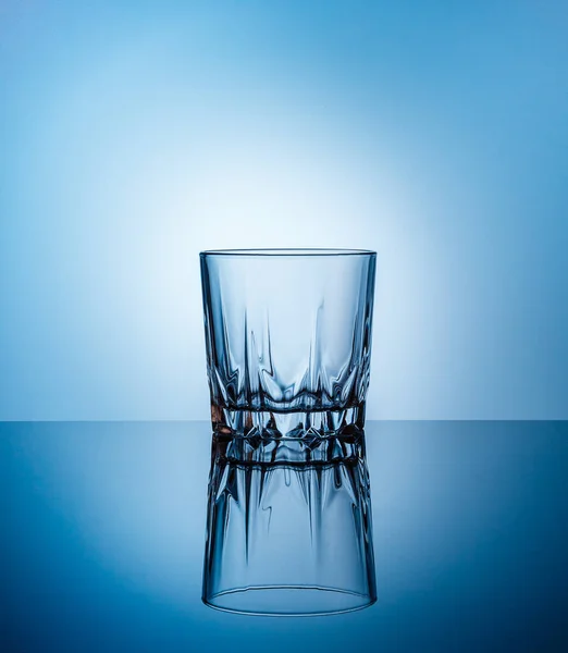 Mavi arka planda boş bir bardak su. Gelenekler olmadan özgür aşkın sembolü. Ekoloji kavramı, dünya toprağının susuzluğu, insan vücudu. Boşluğu kopyala