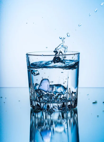 Bir bardak saf temiz su. Bardakta bir damla su. Su sıçratıyorum. Buzlu su. Doğa kavramı, arındırma, tazelik..