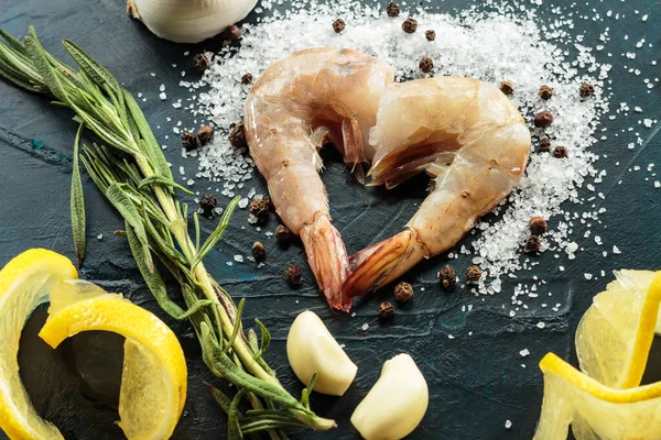 Taze Pasifik beyaz karidesi ya da kral karidesi koyu arkaplanda kalp şeklinde katlanmış. Üst görünüm, yakın çekim, seçici odak