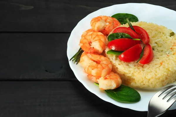 Kızarmış pirinç ve karides, sebzelerle süslenmiş Çin ve Tayland yemek füzyon tarzı popüler menü Tayland 'da beyaz tabak, koyu ahşap arka plan, kopyalama alanı,