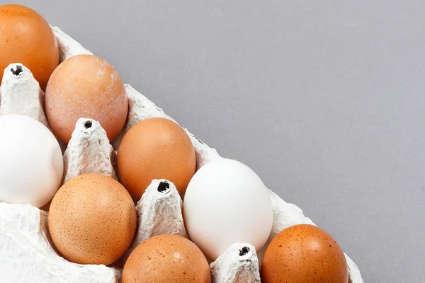 Yumurtalar paketin içinde. Gri arka plandaki hücrelerde tavuk yumurtası. seçici odak