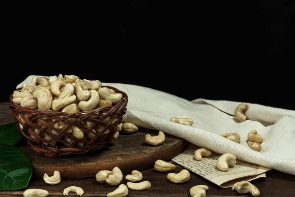 Kurutulmuş fındıklar sepetin içinde, tahtanın üzerinde, koyu arka planda. Seçici odaklanma, kopyalama alanı, sağlıklı gıda konsepti