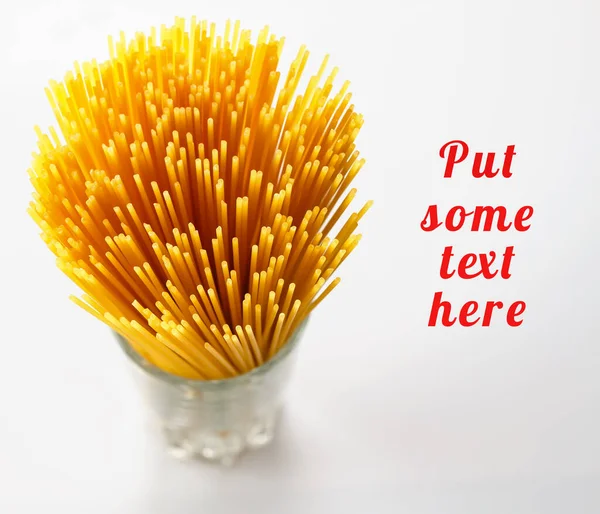 Beyaz arka planda izole edilmiş çiğ makarna. Yapıştırıcı cama konur. Metin için kopyalama alanı olan kart. Sağlıklı yemek, diyet konsepti. seçici odak